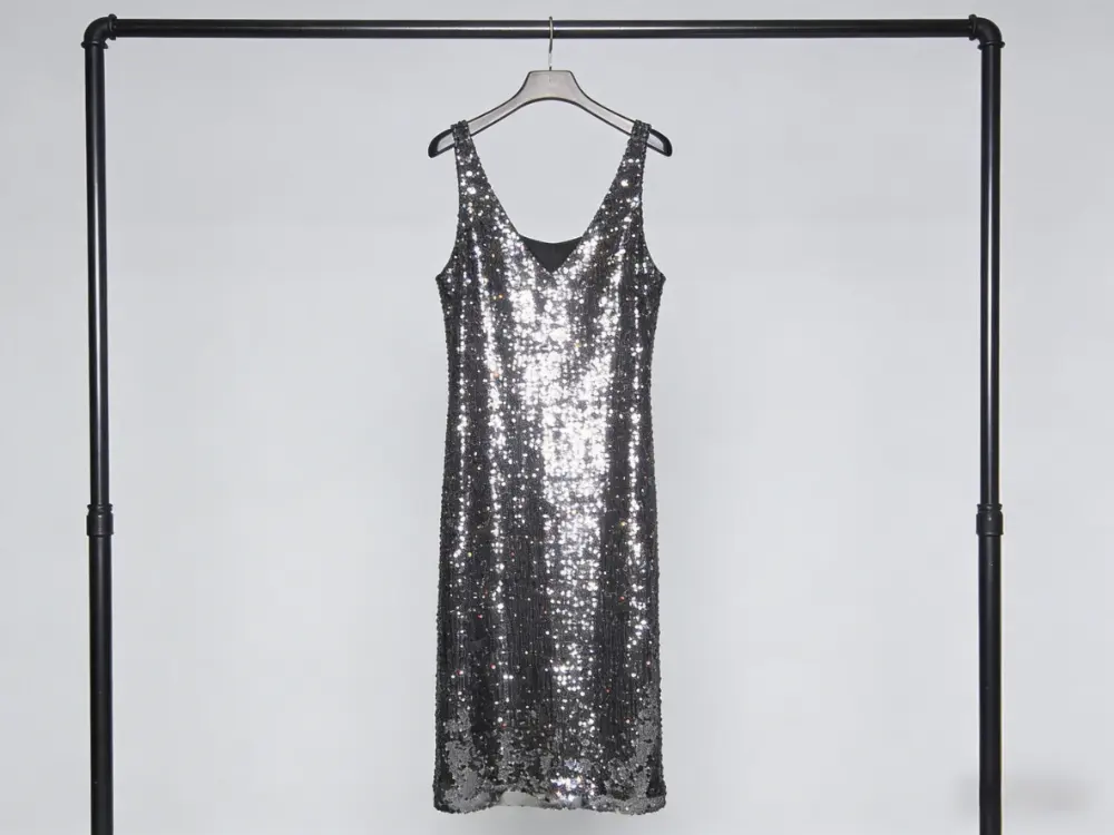 A delicate sequin dress folded flat with acid-free tissue paper for safe, long-term garment storage.