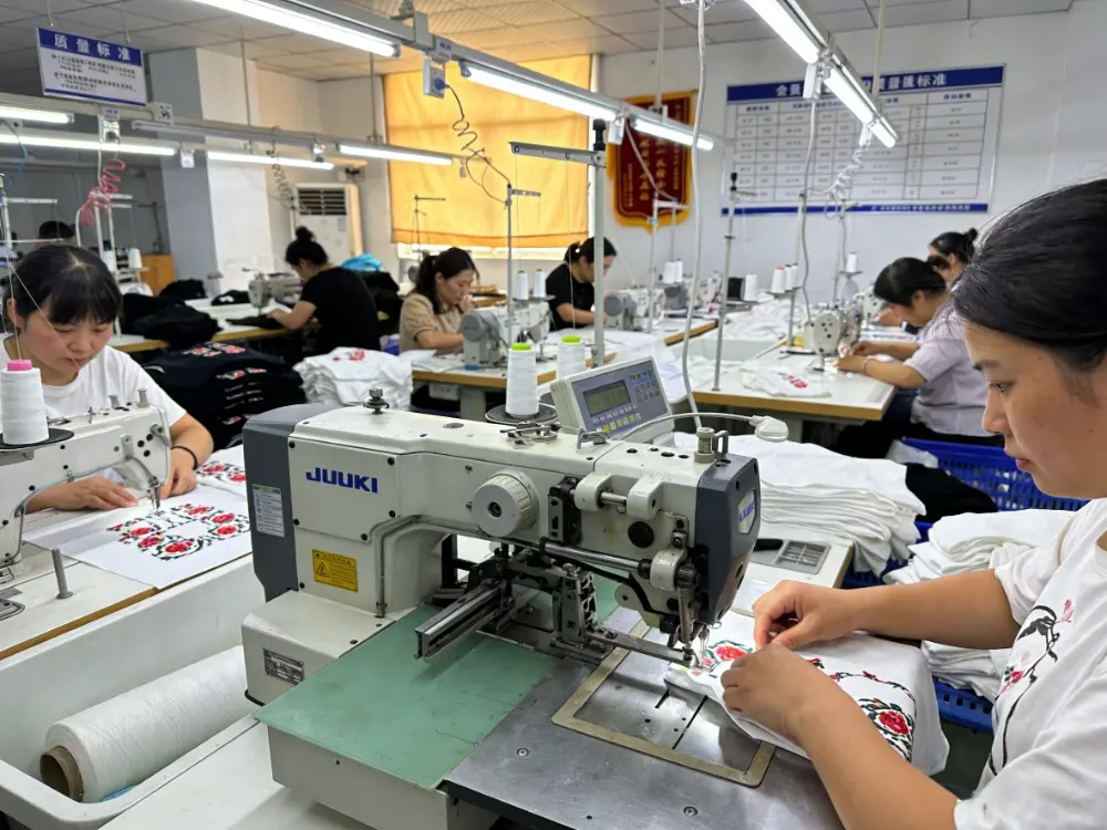 Professional kids dress manufacturers production line showing skilled seamstresses sewing custom private label girls clothing in a certified factory