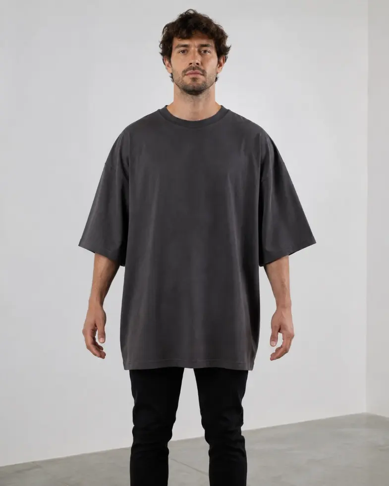 Model wearing a charcoal oversized T-shirt with dropped shoulders and a long hem